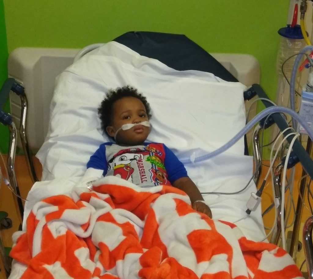 Young child lays in hospital bed 
