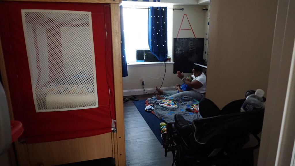 Ms. Chance and her son, Ayden sitting on the floor in their apartment.