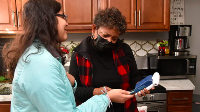 Washington Interfaith Network’s Michelle Hall, right, watches a nitrogen dioxide monitor in her kitchen with fellow WIN organizer Sidra Siddiqui.