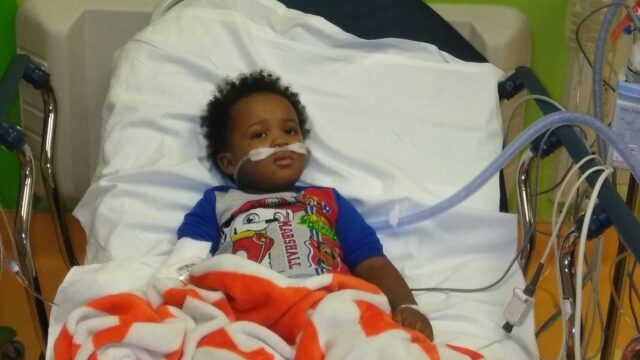 Young child lays in hospital bed