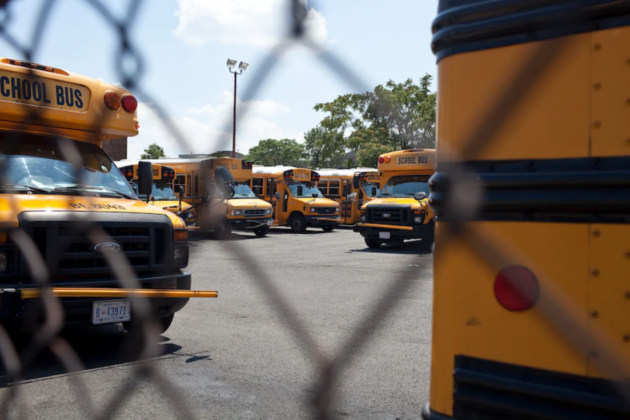 DC school buses behind a fence.