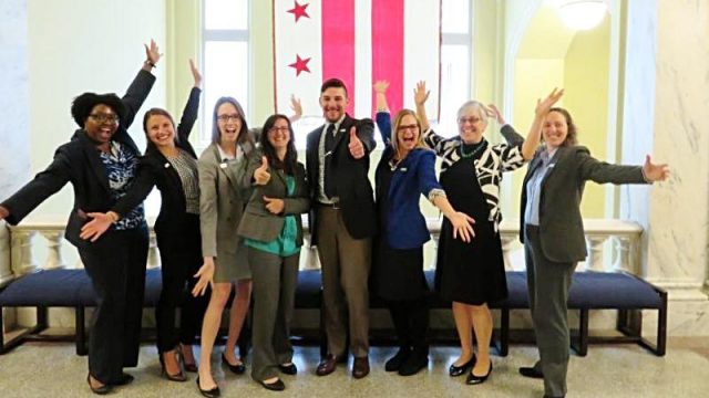 Children's Law Center staff smiling in front of DC flag