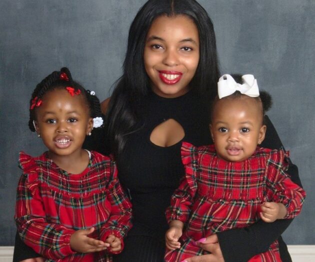 Photo of mom and two daughters smiling at camera.