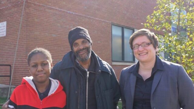 Photo of Destiny, her grandfather Tyrone, and their lawyer Rebecca outside Destiny's new school