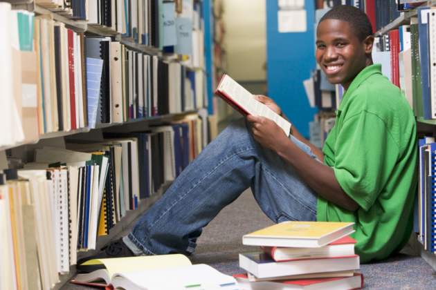 Photo of Carl smiling while studying in a library.