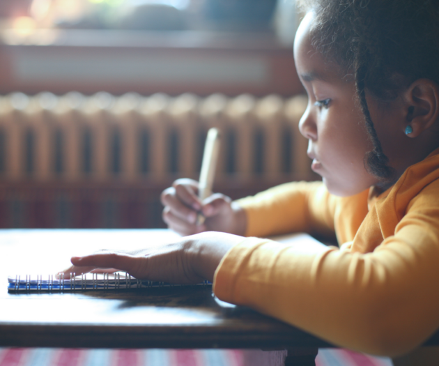 Young girl doing homework at a desk.