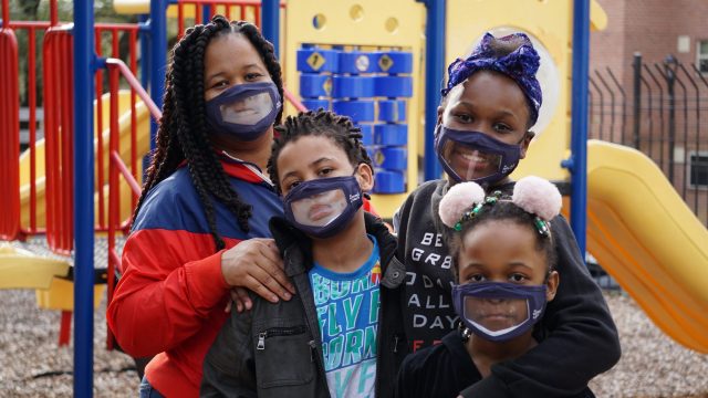Family with masks at playground