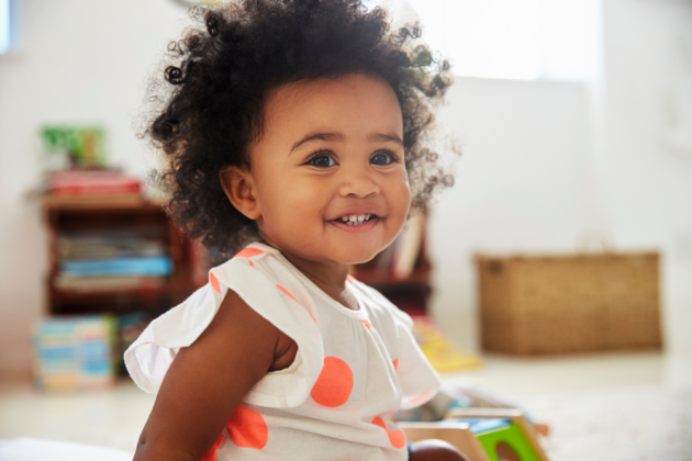 Photo of young child looking past camera and smiling.